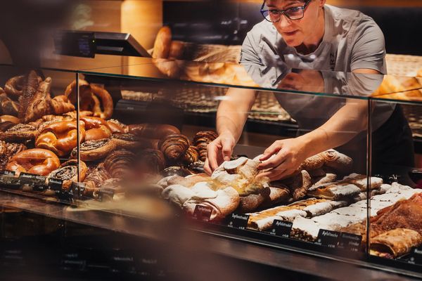 Mitarbeiterin richtet Gebäck in der Theke der Bäckerei Kurz in Galtür
