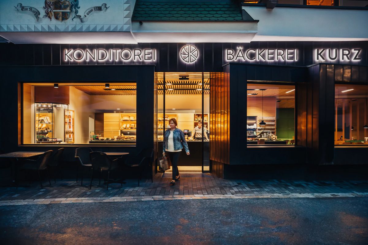 Kundin verlässt die Filiale der Bäckerei Kurz in Ischgl am Abend